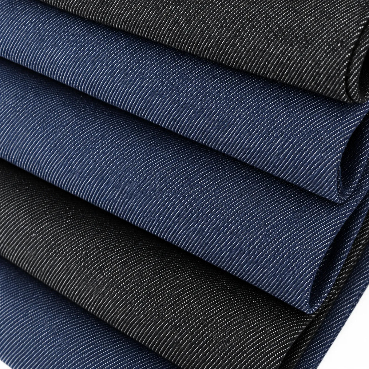 Stacked folded fabric swatches in dark indigo and black, showing a fine ribbed texture.