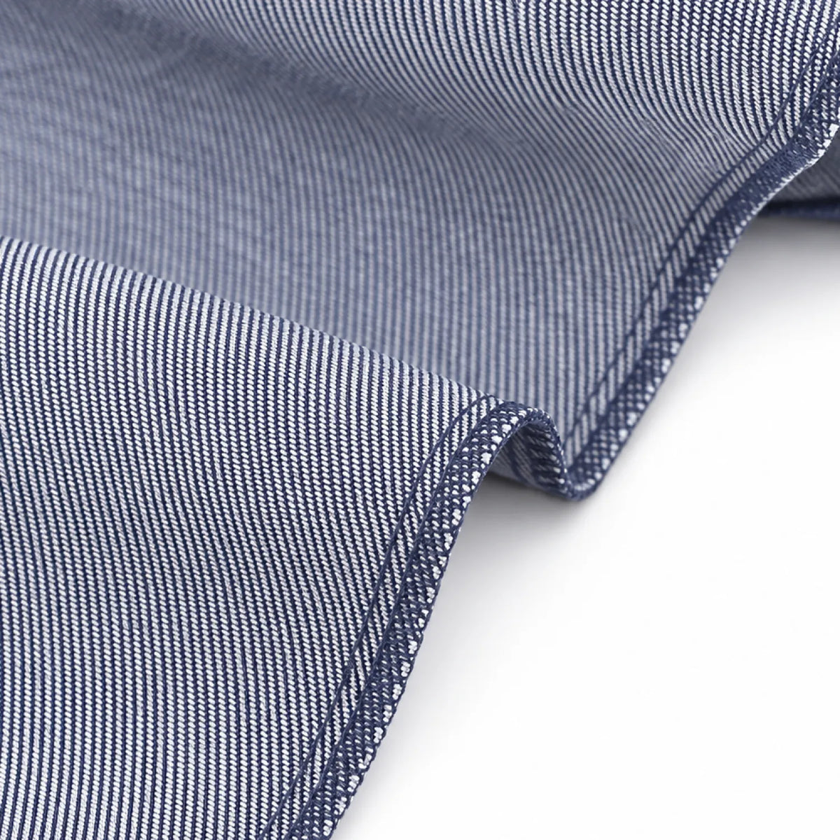 Close-up of the indigo denim-look twill fabric on the wide gusset tote bag, showing the fine diagonal weave and overlocked seam edge