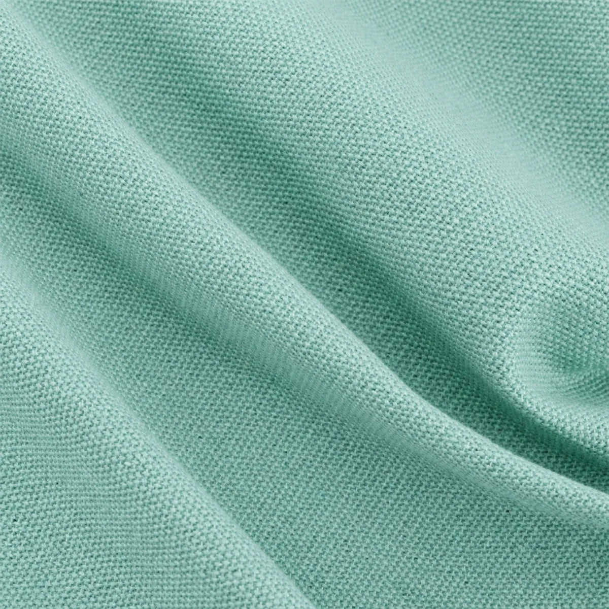 A close-up of soft teal green textured fabric with soft folds and a fine woven pattern.