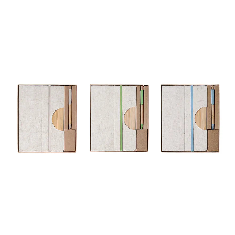 A5 cotton linen notebook and bamboo pen desk kit shown in three elastic band colour variants, natural, green and blue, in kraft gift boxes, viewed from above