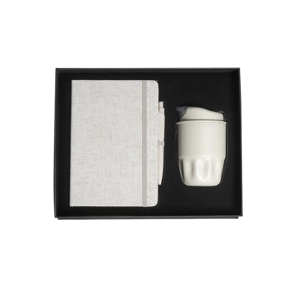 A5 cotton notebook and double-wall coffee cup welcome kit in black magnetic gift box with foam insert, viewed from above, natural colourway, no branding applied