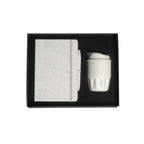 A5 cotton notebook and double-wall coffee cup welcome kit in black magnetic gift box with foam insert, viewed from above, natural colourway, no branding applied