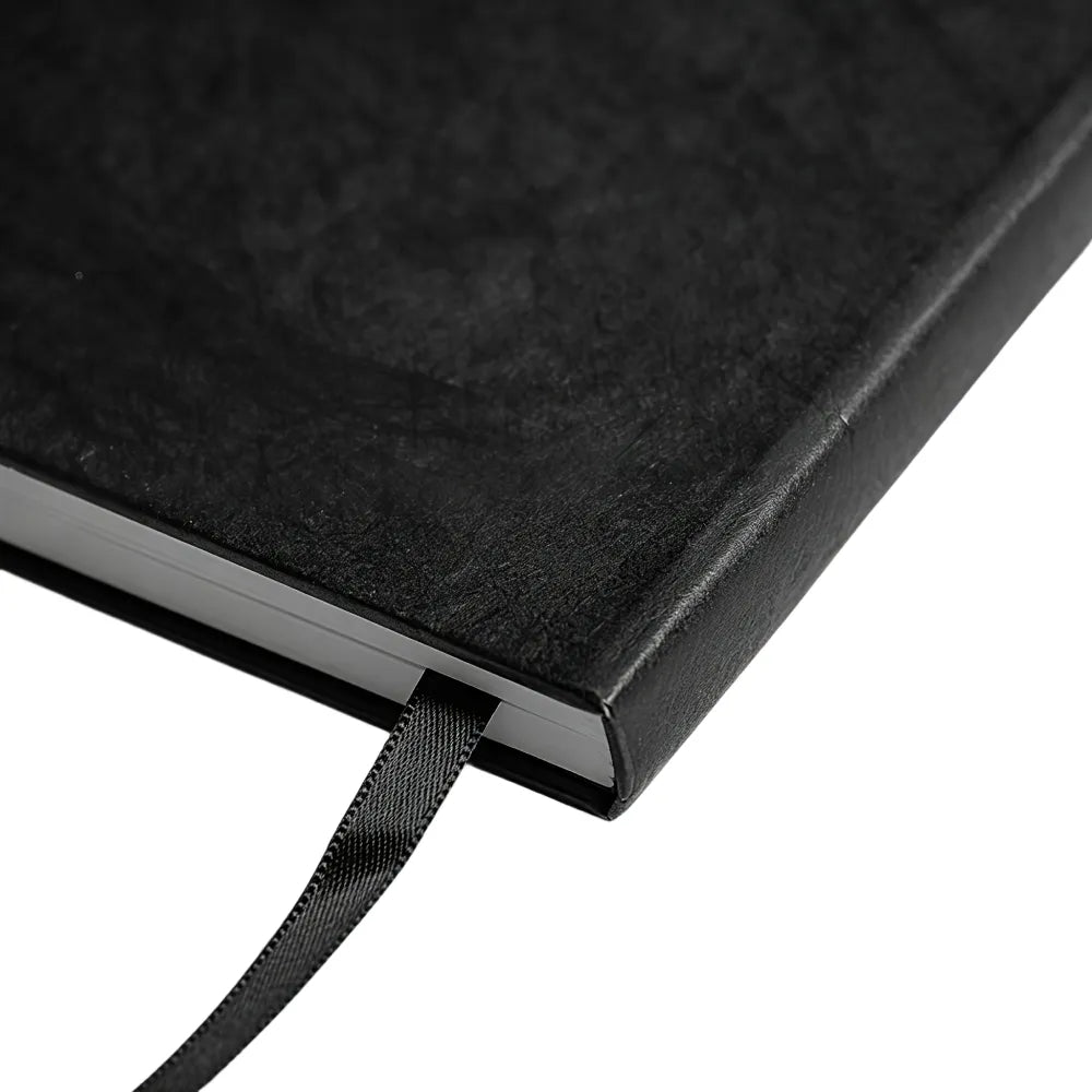 Back of the black A5 notebook on a white background showing the elastic band and pen loop, no Wumble branding applied