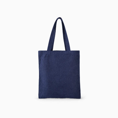 A indigo blue denim tote bag with two shoulder straps, shown against a plain light grey background.
