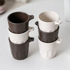 Six Doric recycled coffee grounds tasting cups stacked in two columns, alternating dark brown and off-white colourways, showing the stackable design, no branding applied