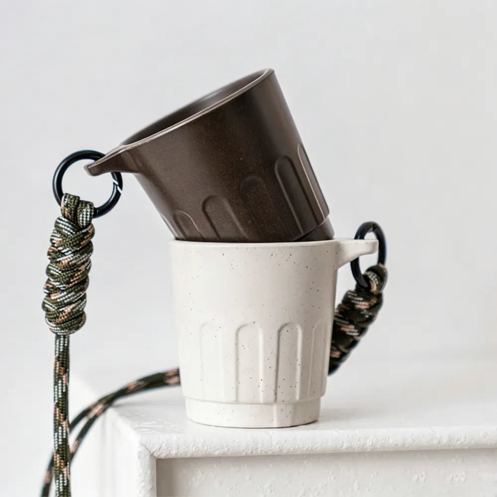 Dark brown 90ml Doric recycled coffee grounds tasting cup on a white background, three-quarter view showing the vertical ribbed Doric profile and side lanyard tab, no branding applied