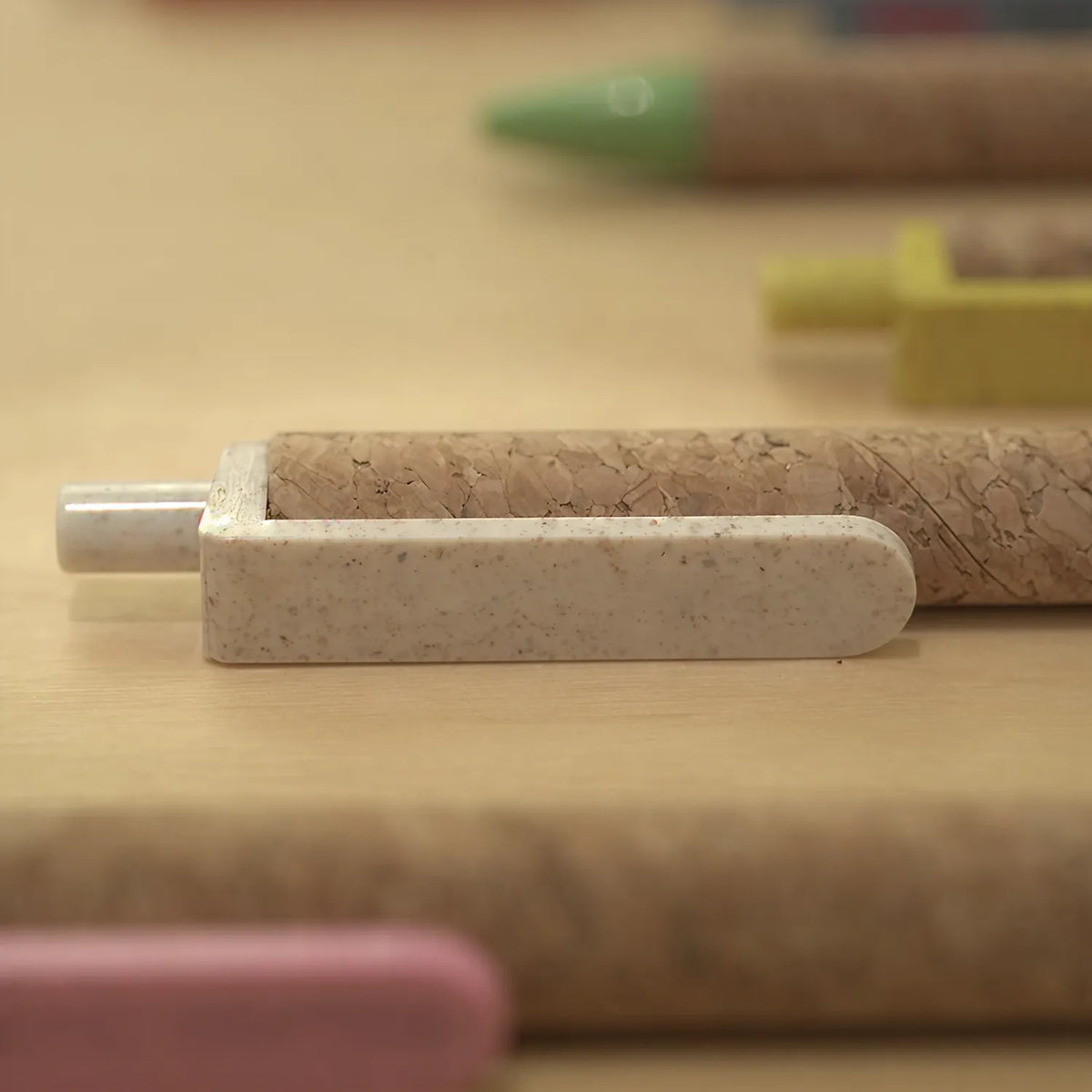Cork & Wheat Straw Gel Pen with natural cork barrel and yellow wheat straw clip, click button and tip, upright on white
