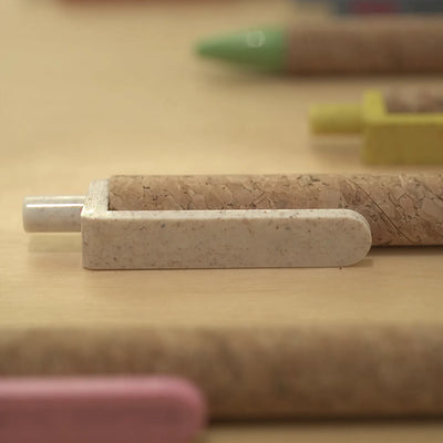 Cork & Wheat Straw Gel Pen with natural cork barrel and yellow wheat straw clip, click button and tip, upright on white