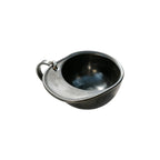 Black 60ml hat-shaped recycled coffee grounds tasting cup on a white background, top three-quarter view showing the hat-brim handle and lanyard ring, no branding applied