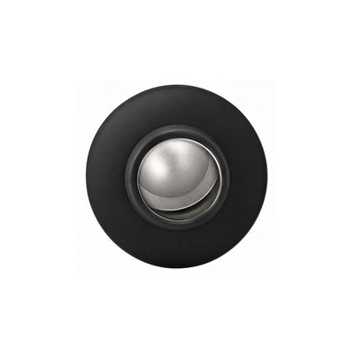 Top-down view into a black drink bottle mouth, showing a rounded silver-toned stopper in the opening.