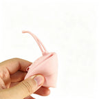 Pink round silicone zip pouch squeezed open in hand to show the soft flexible silicone, no Wumble branding applied