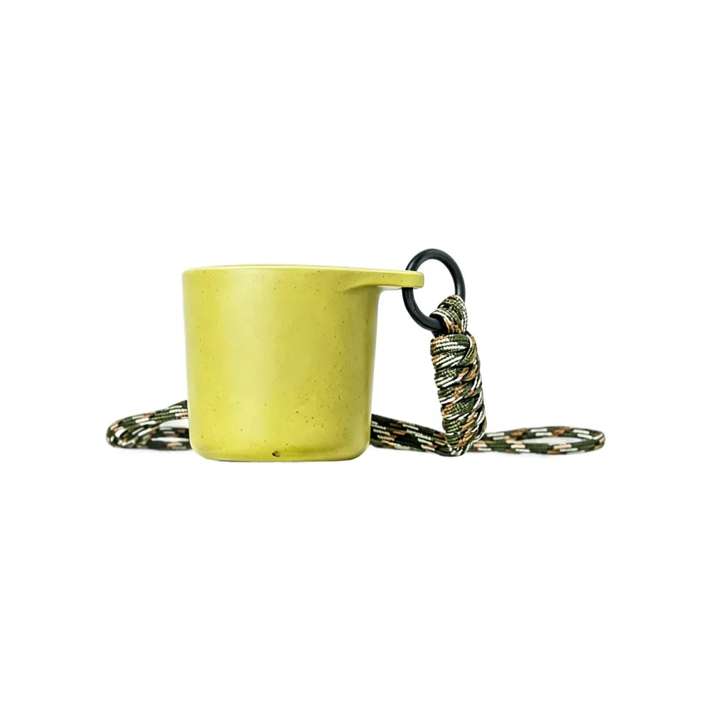 Pear green water drop recycled coffee grounds tasting cup on a white background with a camouflage braided lanyard, speckled finish, no branding applied