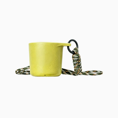Pear green water drop recycled coffee grounds tasting cup on a white background with a camouflage braided lanyard, speckled finish, no branding applied