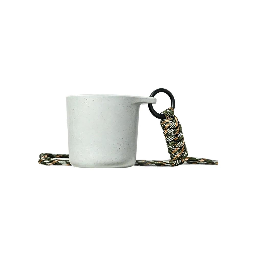 White speckled water drop recycled coffee grounds tasting cup viewed from the front on a white background with a camouflage braided lanyard, no branding applied