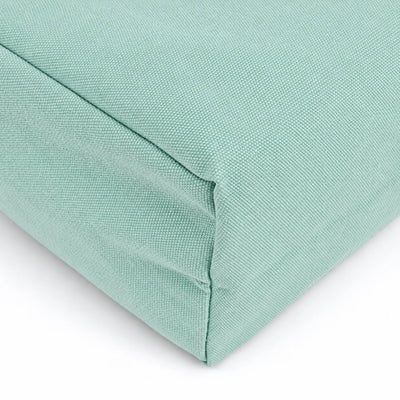 A close-up of a soft teal green fabric cushion corner showing the woven texture and stitched seam against a white background.
