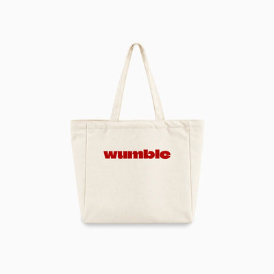 An off-white canvas tote bag with two shoulder straps and customised logo 'Wumble' example printed in red across the front, shown against a plain white background.