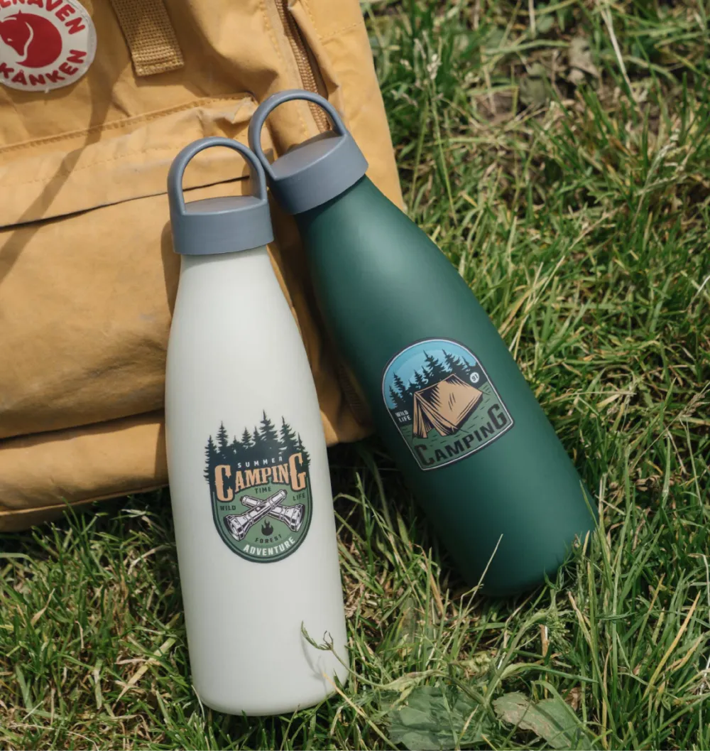 Cream white and deep forest green 750ml PLA bottle-style travel cup with a grey loop-top lid on a outdoor grass, branding applied